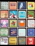 Fossil Jewelry Catalog: A collection of stainless steel and leather jewelry pieces from the Fossil catalog displayed on a wooden surface.