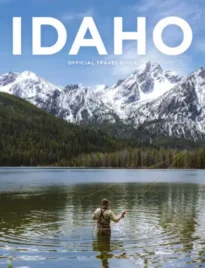 Idaho Travel Guide: A scenic view of the Sawtooth Mountains in Idaho with a clear blue alpine lake in the foreground.