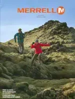 A collection of Merrell hiking boots and trail running shoes arranged on a wooden surface representing the Merrell Catalog.