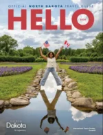 North Dakota Travel Guide: The rugged landscape of Theodore Roosevelt National Park in North Dakota featuring eroded buttes and green valleys under a blue sky.