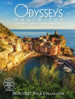 Odysseys Unlimited Travel Catalog: A small group of travelers standing in front of an ancient historical monument with a local guide explaining the history.