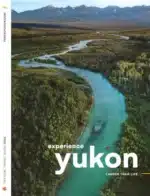 Yukon Vacation Planner: A scenic view of a winding road through the Yukon mountains with autumn tundra colors.